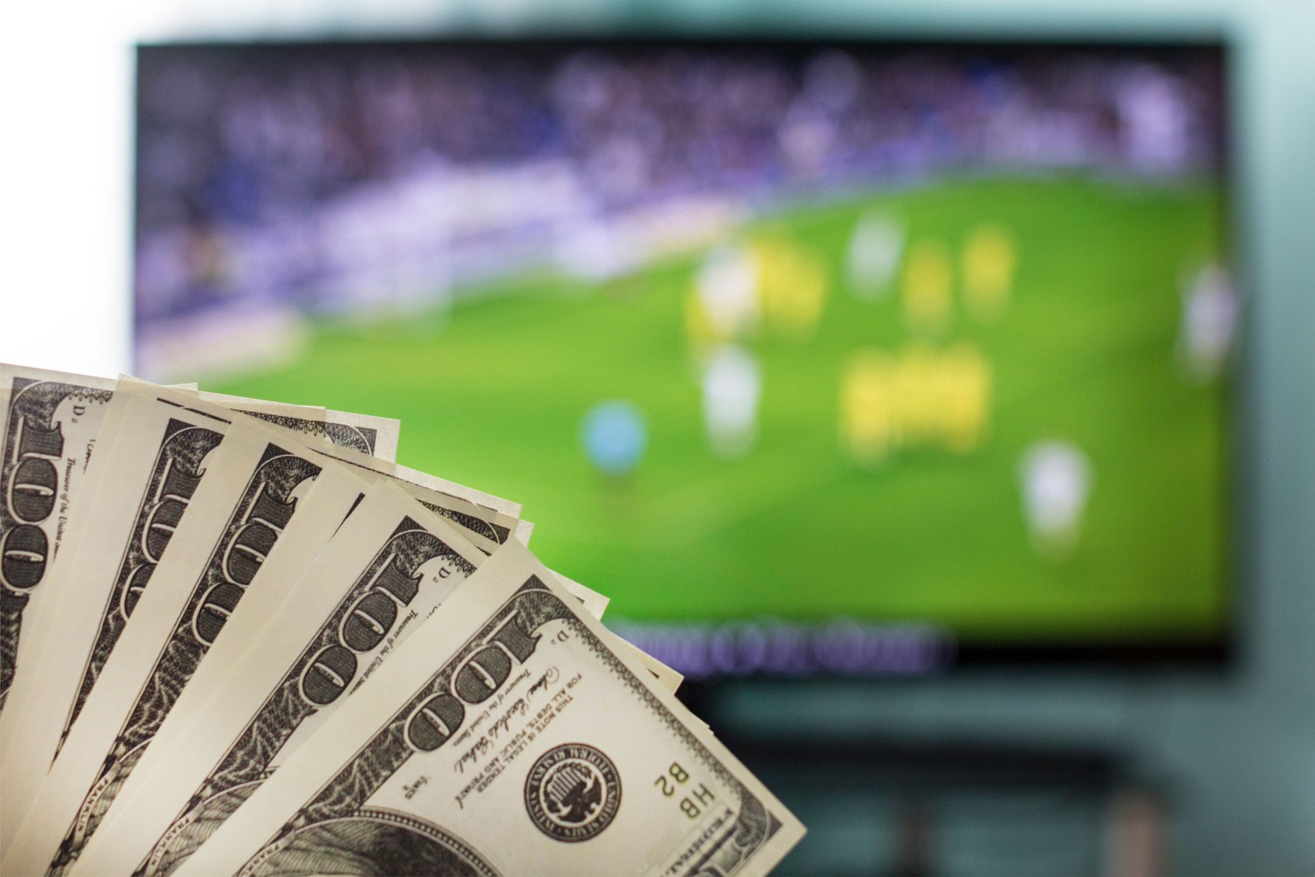 Dollars against the backdrop of a TV set for football, football and money